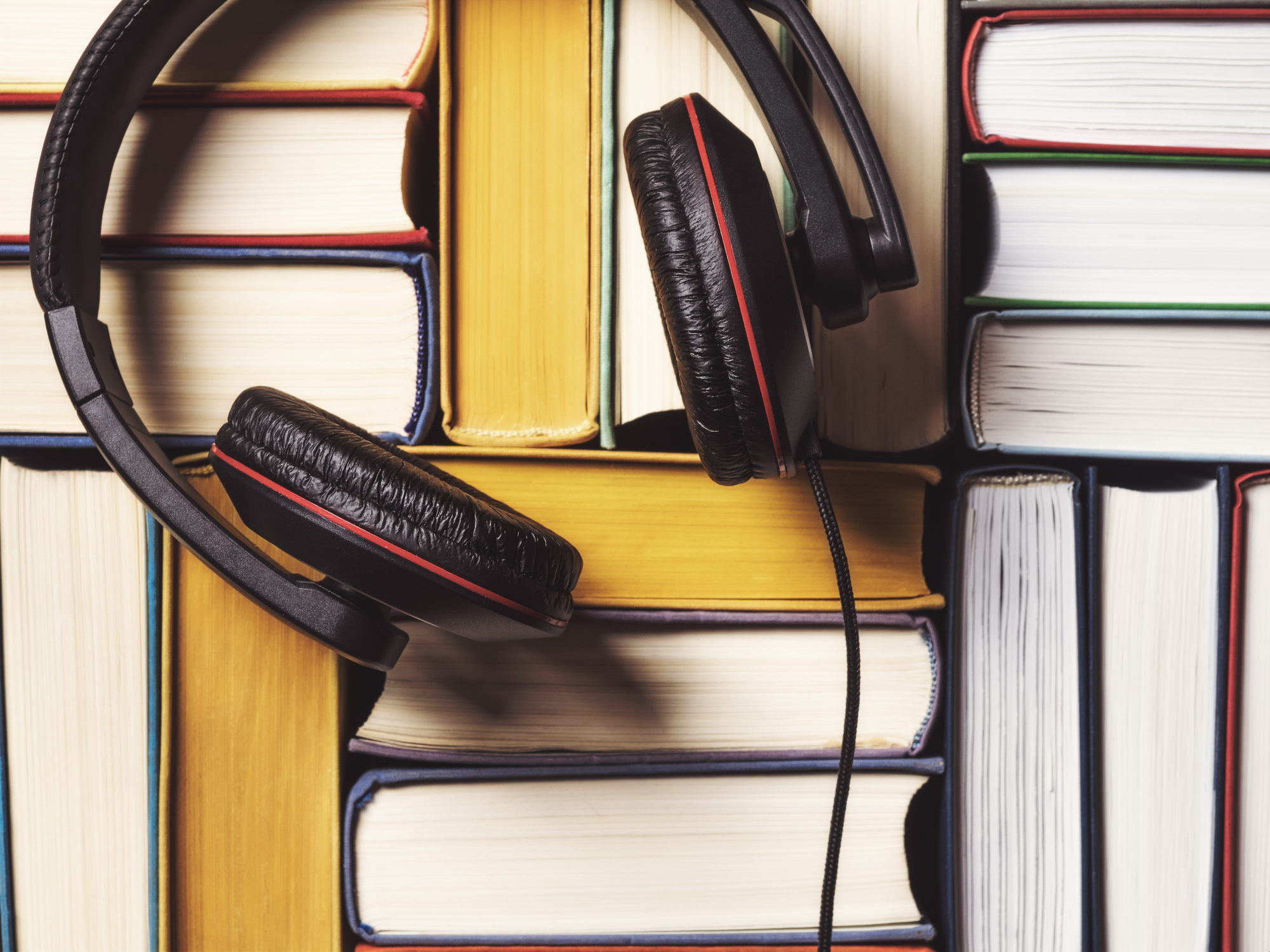 Бесплатные библиотеки аудиокниг слушать. Аудиокниги фото. Книга и наушники. Прослушивание аудиокниг. Стопка книг и наушники.